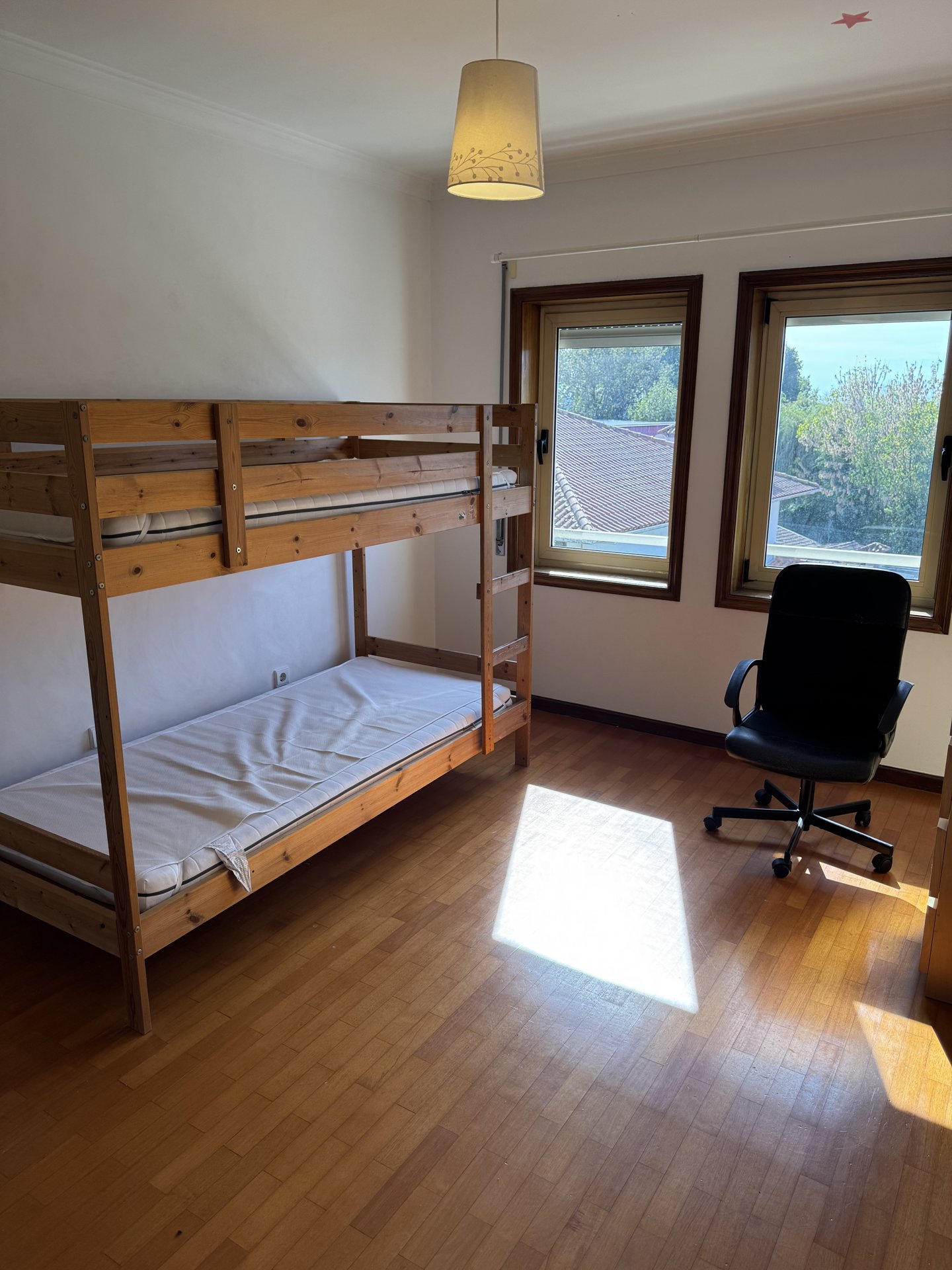 A bunk-bed room with a desk by the window